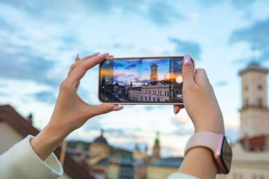 Akıllı telefon tutan ve Lviv, Ukrayna 'da fotoğraf çeken kadın eller.