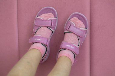 Lviv, Ukrayna - 24 Mayıs 2024: Çocuk ayaklarında pembe Geox Vaniett sandaletleri