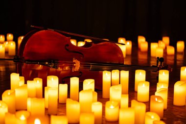 closeup of violin with lots of candles for design purpose clipart