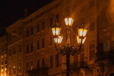 Lviv, Ukrayna 'daki pazar meydanında yağmurlu bir gecede fenerin kapatılması