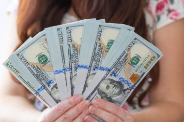Kadın, tasarım amaçlı 100 dolarlık banknotları tutuyor.