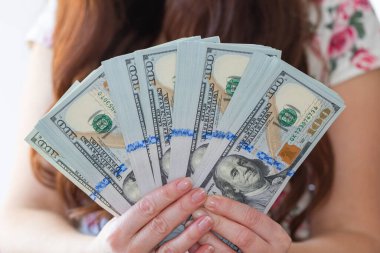Kadın, tasarım amaçlı 100 dolarlık banknotları tutuyor.