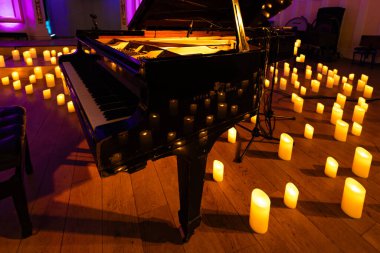 Lviv, Ukrayna - 30 Ocak 2024: Steinway and Sons siyah piyano ve bir sürü mum