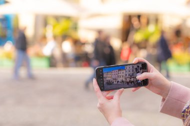 Akıllı telefon tutan ve Lviv, Ukrayna 'da fotoğraf çeken kadın eller.