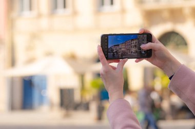 Akıllı telefon tutan ve Lviv, Ukrayna 'da fotoğraf çeken kadın eller.