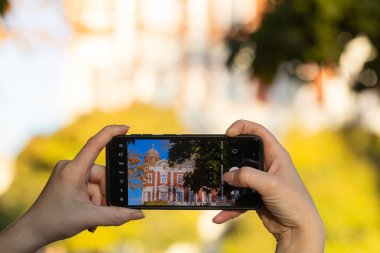 Akıllı telefon tutan ve Lviv, Ukrayna 'da fotoğraf çeken kadın eller.