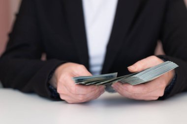 Kadın elleri tasarım amaçlı 100 dolarlık banknotları sayıyor.