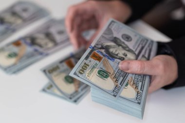 Kadın, tasarım amaçlı 100 dolarlık banknotları tutuyor.