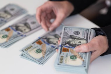 Kadın, tasarım amaçlı 100 dolarlık banknotları tutuyor.
