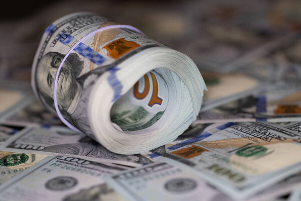 рулон банкнот 100 долларов США на фоне банкнот 100 долларов США для дизайнерских целей