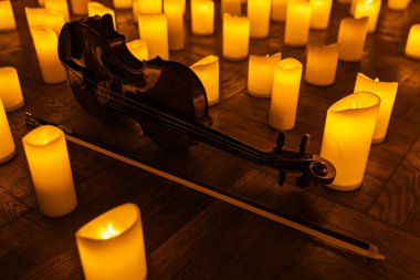 closeup of violin with lots of candles for design purpose clipart