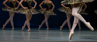 Sahnede dans eden balerinlerin yakın çekimi.