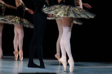 Sahnede dans eden balerinlerin yakın çekimi.