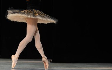 Sahnede dans eden balerinlerin yakın çekimi.