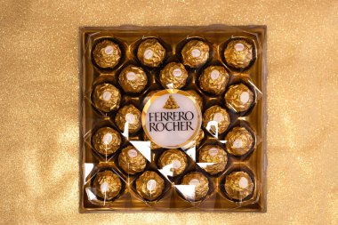 İtalya - 6 Aralık 2024: Ferrero Rocher altın parıltılı arka planda özel çikolata
