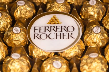 İtalya - 6 Aralık 2024: Ferrero Rocher altın parıltılı arka planda özel çikolata