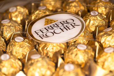 İtalya - 6 Aralık 2024: Ferrero Rocher altın parıltılı arka planda özel çikolata