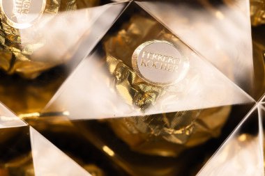 İtalya - 6 Aralık 2024: Ferrero Rocher altın parıltılı arka planda özel çikolata