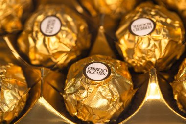 İtalya - 6 Aralık 2024: Ferrero Rocher altın parıltılı arka planda özel çikolata