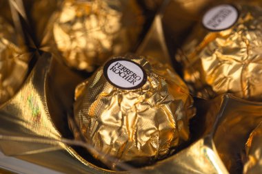 İtalya - 6 Aralık 2024: Ferrero Rocher altın parıltılı arka planda özel çikolata