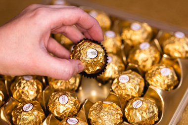 İtalya - 6 Aralık 2024: Ferrero Rocher altın parıltılı arka planda özel çikolata