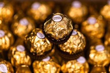 İtalya - 6 Aralık 2024: Ferrero Rocher altın parıltılı arka planda özel çikolata