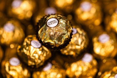 İtalya - 6 Aralık 2024: Ferrero Rocher altın parıltılı arka planda özel çikolata