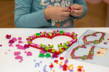 Lviv, Ukrayna - 3 Şubat 2025: Lego Kalp Süslemesi yapan çocuk