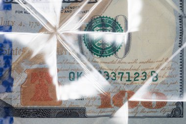 Şeffaf kıvrımlı plastik altında tasarım amaçlı 100 dolarlık banknot