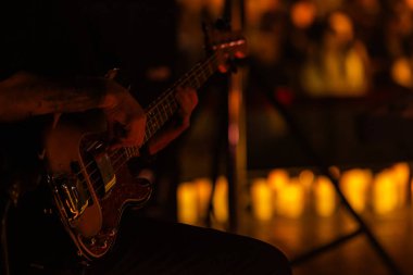 Gitarist konser sahnesinde dizayn amaçlı bir sürü mumla