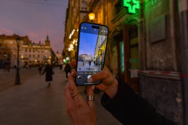 Akıllı telefon tutan ve Lviv, Ukrayna 'da fotoğraf çeken kadın eller.