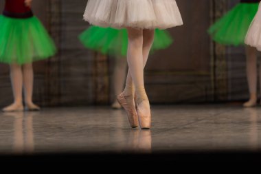 Sahnede yapayalnız dans eden balerinin yakın çekimi. Balerin bacakları yakın plan