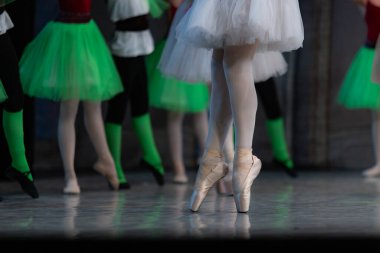 Sahnede yapayalnız dans eden balerinin yakın çekimi. Balerin bacakları yakın plan