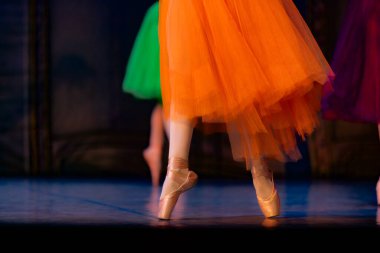 Sahnede yapayalnız dans eden balerinin yakın çekimi. Balerin bacakları yakın plan