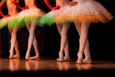 Sahnede yapayalnız dans eden balerinin yakın çekimi. Balerin bacakları yakın plan