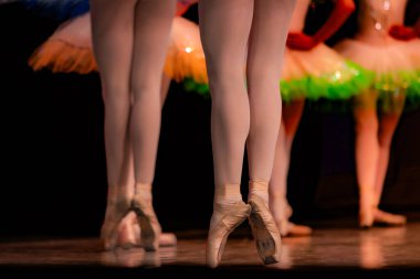 Sahnede yapayalnız dans eden balerinin yakın çekimi. Balerin bacakları yakın plan