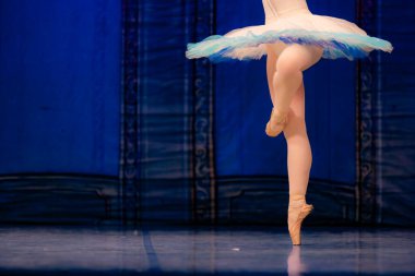 Sahnede yapayalnız dans eden balerinin yakın çekimi. Balerin bacakları yakın plan