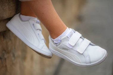 Lviv, Ukrayna - 26 Temmuz 2024: Velcro kayışlı Beyaz Puma Spor Ayakkabılı Çocuk Ayakları