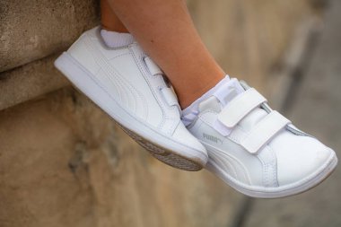 Lviv, Ukrayna - 26 Temmuz 2024: Velcro kayışlı Beyaz Puma Spor Ayakkabılı Çocuk Ayakları