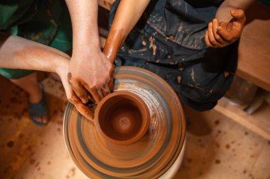 Yetişkin ve Çocuk Elleri Tekerlekli Çömlek Yapıyor