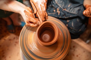 Yetişkin ve Çocuk Elleri Tekerlekli Çömlek Yapıyor