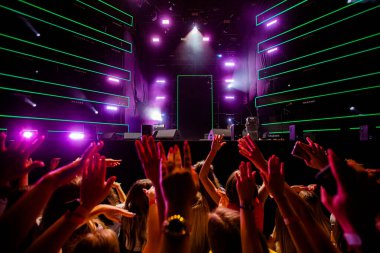 Yeşil Neon Işıklı Bir Konserde Kaldırılmış Elleri Olan Kalabalık