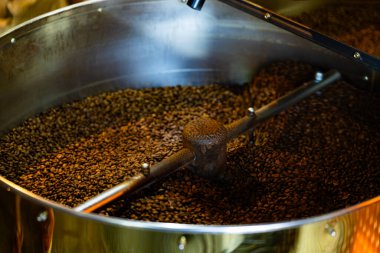 Taze kavrulmuş kahve. Fasulyeler fırında yuvarlanıyor.