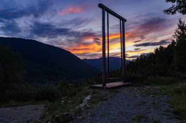 Gün batımında tepede sallanan dev ahşap salıncak..