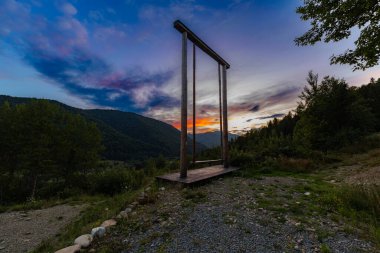 Gün batımında tepede sallanan dev ahşap salıncak..