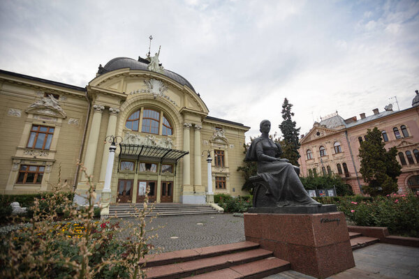 Черновцы, Украина - 12 июля 2025 года: Фасад Черновицкого драматического театра со статуей Ольги Кобылянской