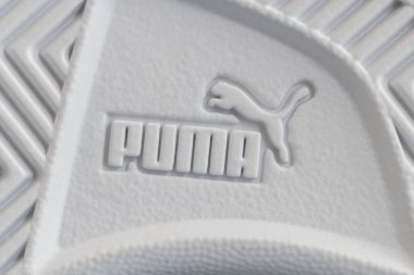 Lviv, Ukrayna - 24 Ağustos 2025: Renkli yamalı, arka planda kırmızı ayakkabı kutusu olan yeni bir çift beyaz çocuk ayakkabısı.