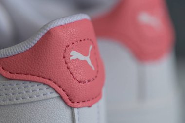 Lviv, Ukrayna - 24 Ağustos 2025: Renkli yamalı, arka planda kırmızı ayakkabı kutusu olan yeni bir çift beyaz çocuk ayakkabısı.