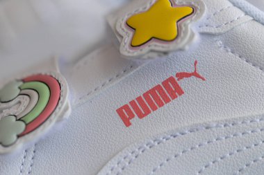 Lviv, Ukrayna - 24 Ağustos 2025: Renkli yamalı, arka planda kırmızı ayakkabı kutusu olan yeni bir çift beyaz çocuk ayakkabısı.