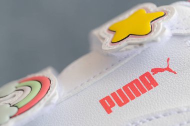 Lviv, Ukrayna - 24 Ağustos 2025: Renkli yamalı, arka planda kırmızı ayakkabı kutusu olan yeni bir çift beyaz çocuk ayakkabısı.